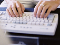 Eine Frau tippt etwas auf einer Tastatur ein Eine Frau tippt etwas auf einer Tastatur ein